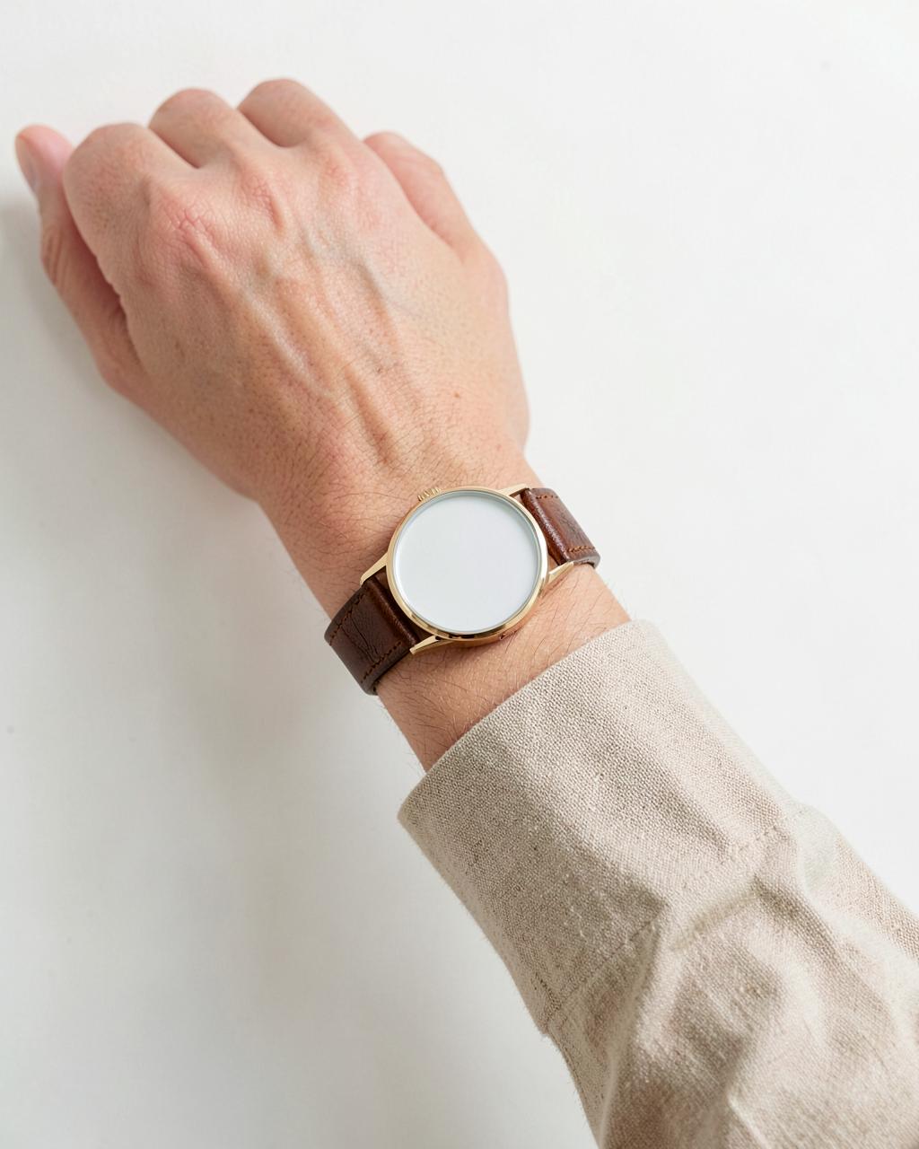 A leather-strap watch worn on a wrist